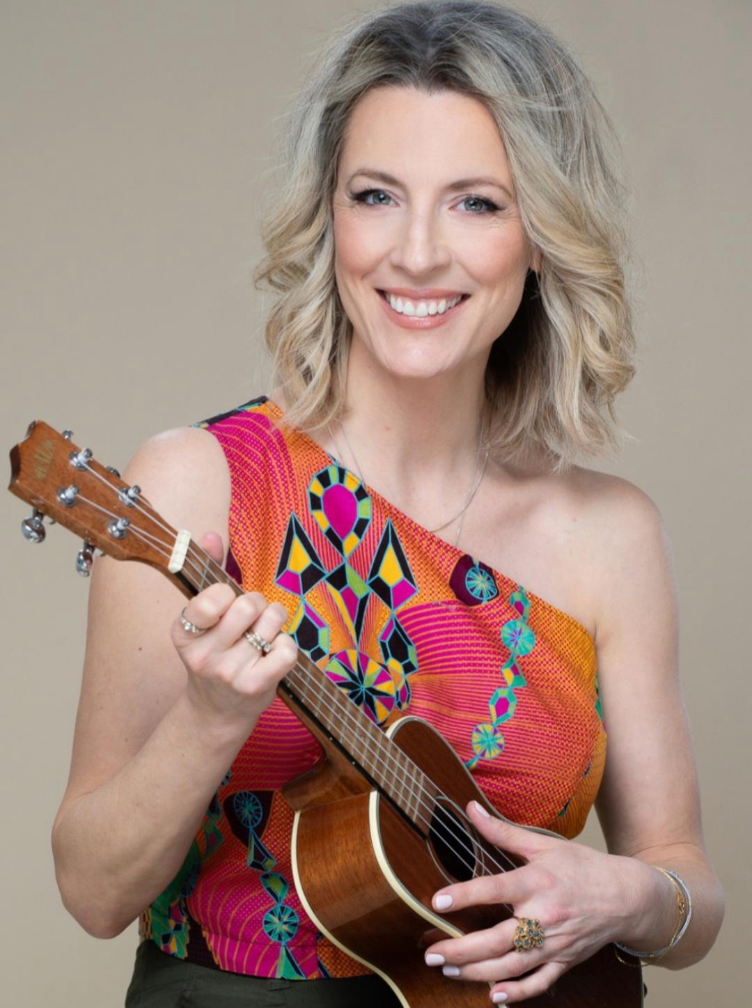 Mia smiling while holding a ukulele